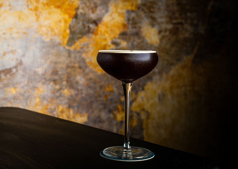 Espresso Martini cocktail at Fraiche DC with gold wall backdrop
